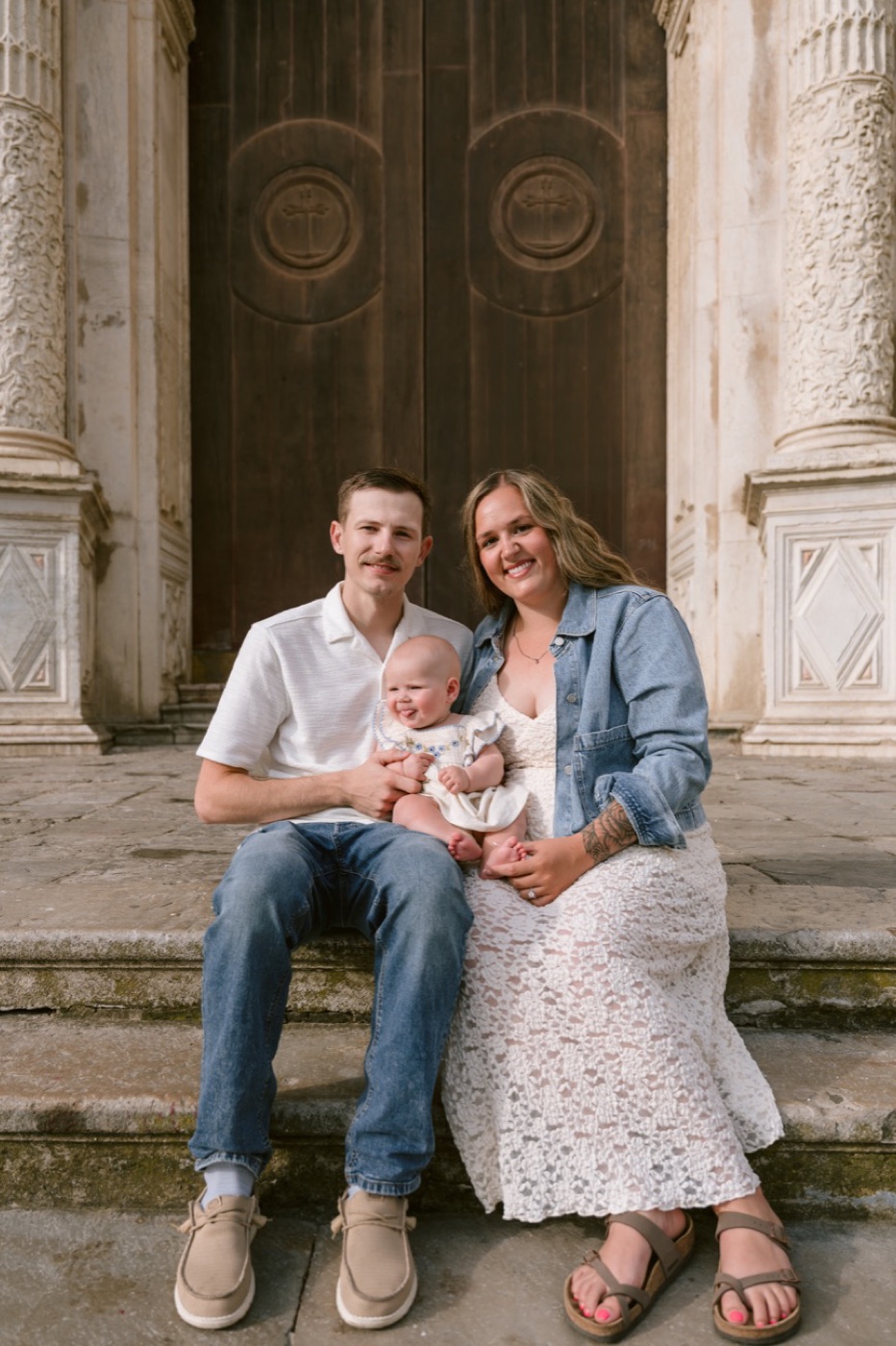 Zachary Gould with his wife and baby daughter on church steps in Spain